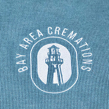 A lighthouse logo embroidered in white on a sage quarter-zip