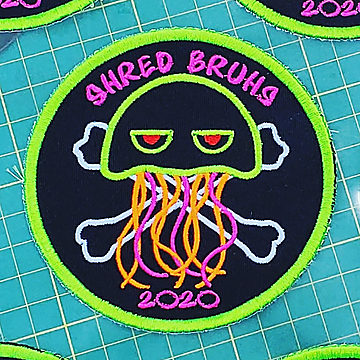 A round Shred Bruhs patch with a neon squid over crossbones