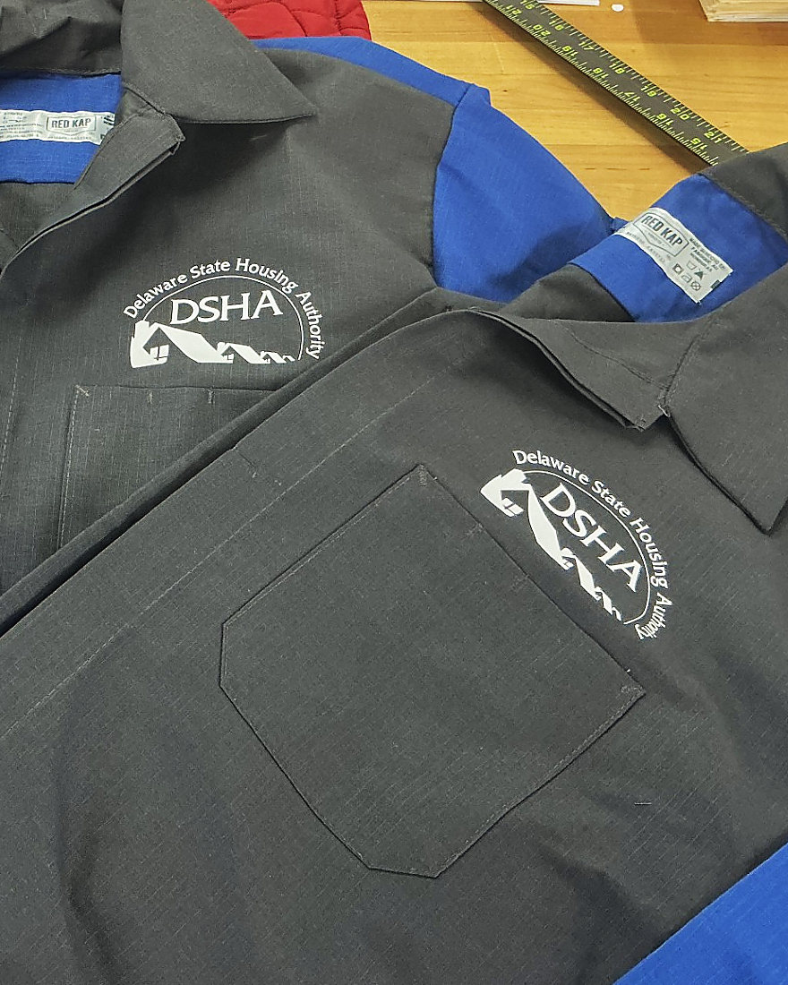 Grey and blue work shirts with the Delaware State Housing Authority logo on the chest