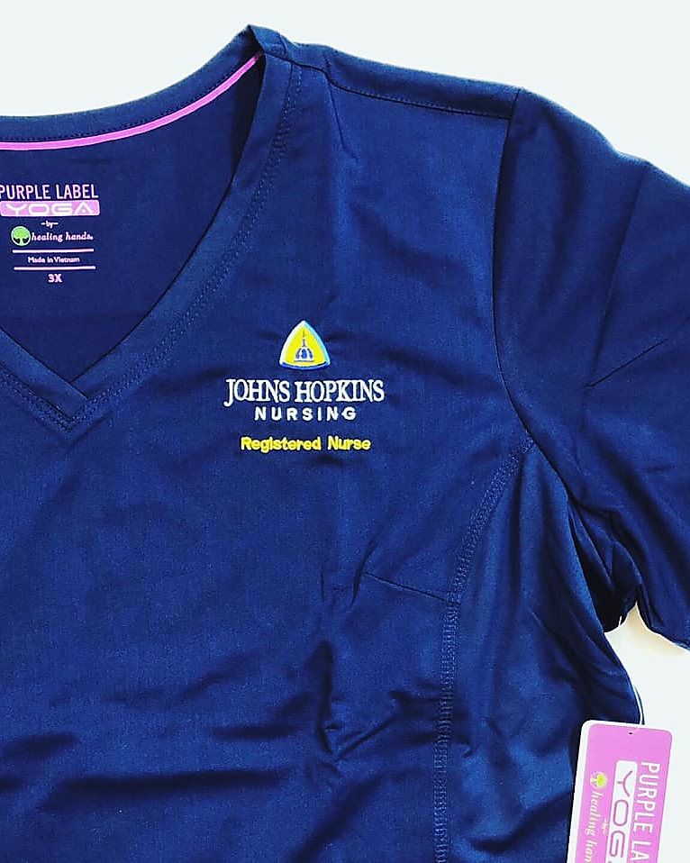 An embroidered Johns Hopkins Nursing scrub top